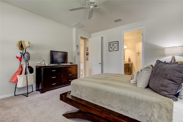 bedroom with connected bathroom, light colored carpet, and ceiling fan