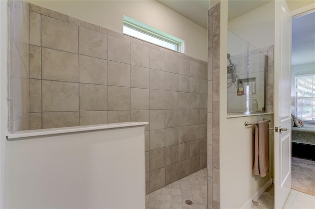 bathroom with tile patterned flooring, a healthy amount of sunlight, and tiled shower