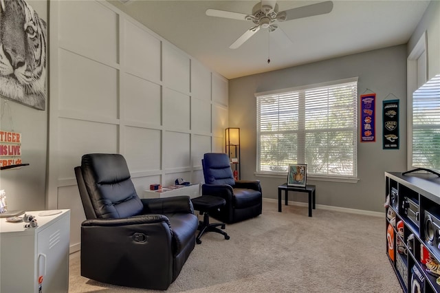 living area featuring light carpet and ceiling fan