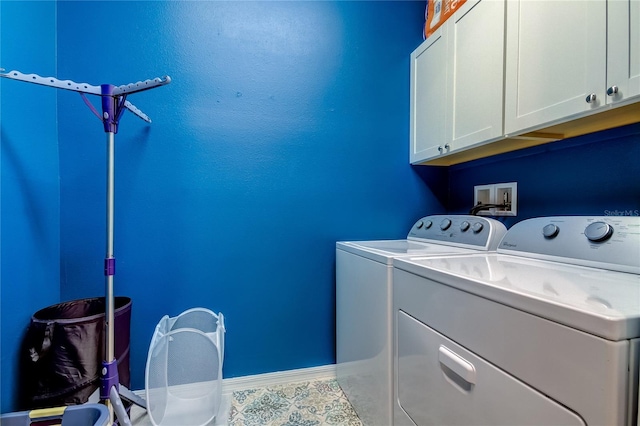 laundry room with tile patterned floors, washer and dryer, and cabinets