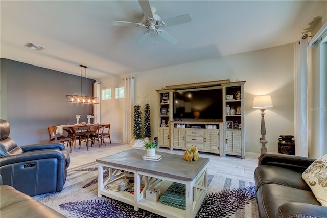 living room with ceiling fan with notable chandelier