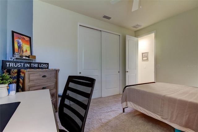 bedroom featuring a closet, light colored carpet, and ceiling fan