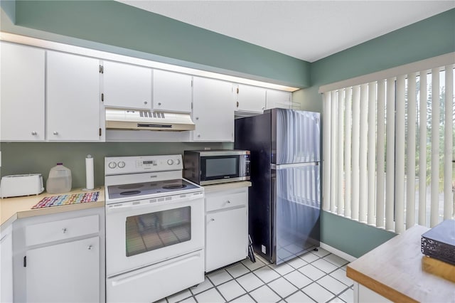 kitchen with white cabinets, appliances with stainless steel finishes, and light tile patterned flooring