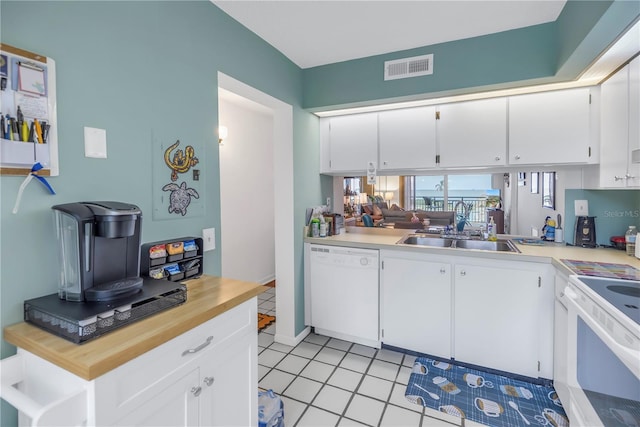 kitchen featuring white appliances, white cabinetry, sink, and kitchen peninsula