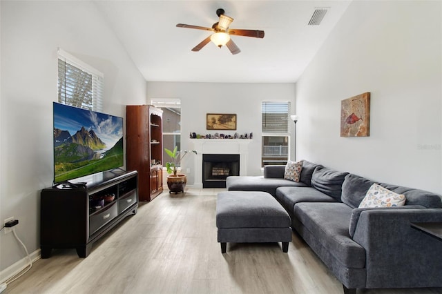 living room featuring light hardwood / wood-style flooring, ceiling fan, and vaulted ceiling