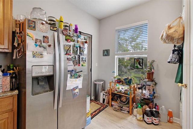 kitchen with stainless steel refrigerator with ice dispenser and light hardwood / wood-style flooring