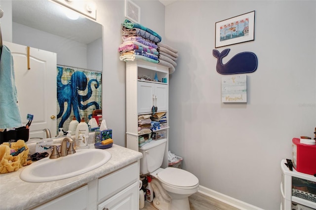 bathroom featuring hardwood / wood-style floors, vanity, and toilet