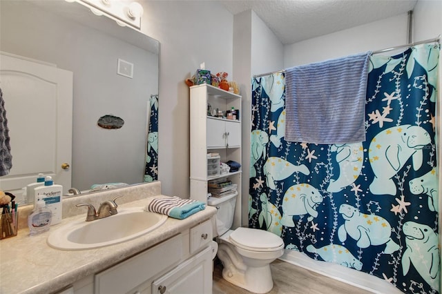 bathroom with a shower with curtain, vanity, a textured ceiling, hardwood / wood-style flooring, and toilet