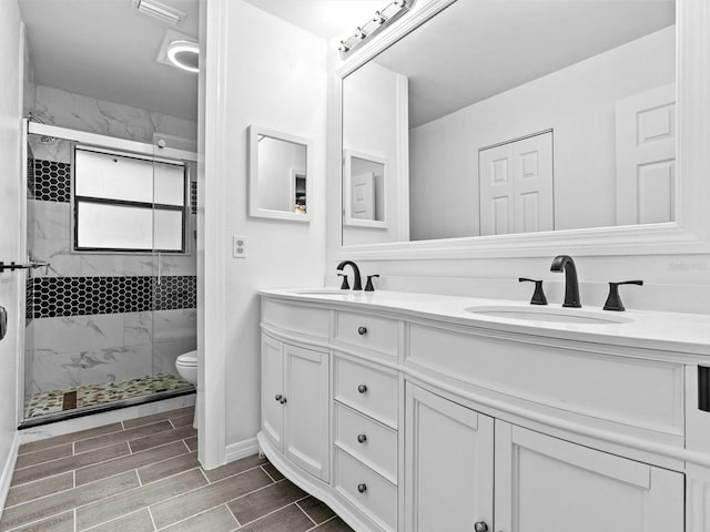 bathroom featuring vanity, toilet, and an enclosed shower