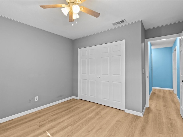 unfurnished bedroom with ceiling fan, a closet, and light wood-type flooring