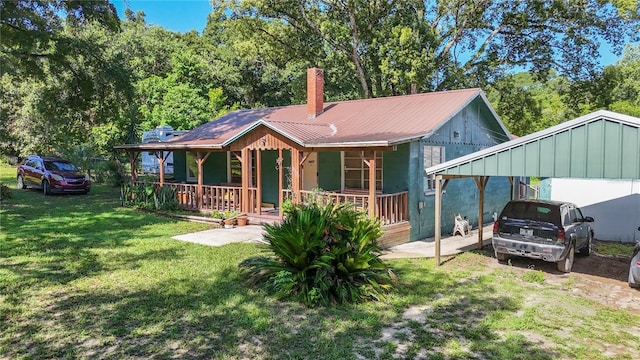 view of front facade with a front yard, covered porch, and a carport