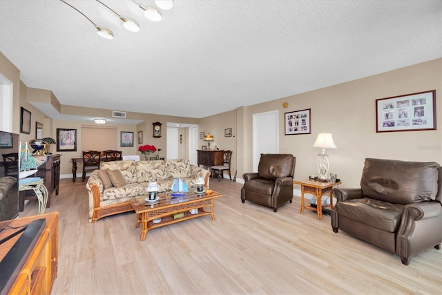 living room with light hardwood / wood-style floors and a textured ceiling