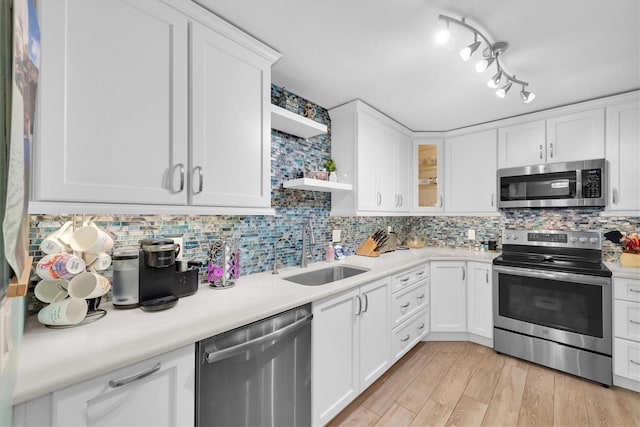 kitchen featuring light hardwood / wood-style flooring, appliances with stainless steel finishes, sink, and white cabinets