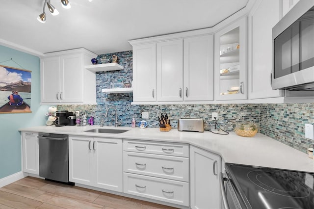 kitchen with stainless steel appliances, white cabinetry, sink, and tasteful backsplash