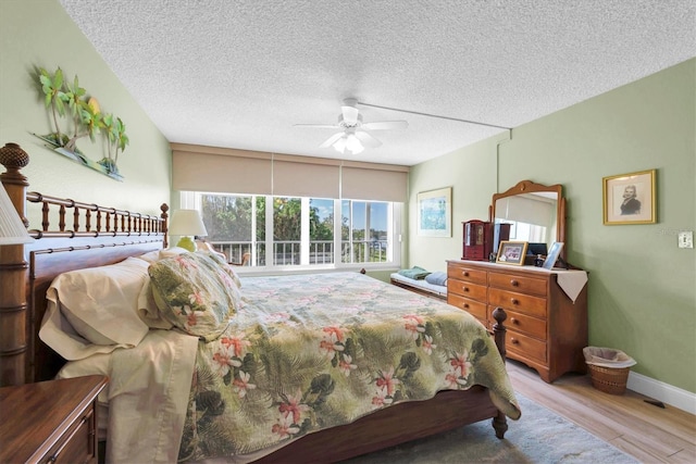 bedroom featuring a textured ceiling, light wood-type flooring, and ceiling fan