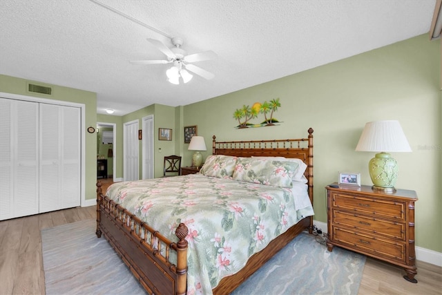 bedroom with ceiling fan, a textured ceiling, a closet, and light wood-type flooring