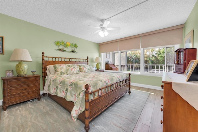 bedroom featuring ceiling fan, a textured ceiling, and light wood-type flooring