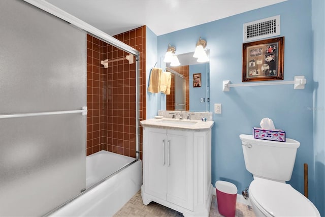 full bathroom featuring toilet, combined bath / shower with glass door, vanity, and tile patterned flooring