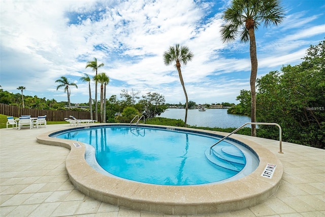 view of swimming pool featuring a water view and a patio