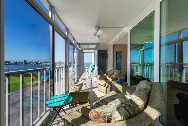 sunroom / solarium with ceiling fan and a water view