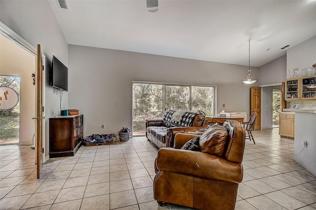 living room featuring high vaulted ceiling, a wealth of natural light, and light tile patterned floors