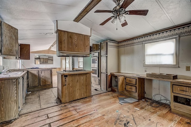 kitchen featuring a center island, vaulted ceiling, sink, ceiling fan, and light hardwood / wood-style flooring