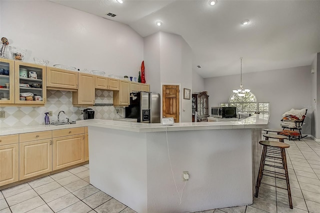 kitchen featuring light brown cabinets, stainless steel appliances, hanging light fixtures, and a chandelier