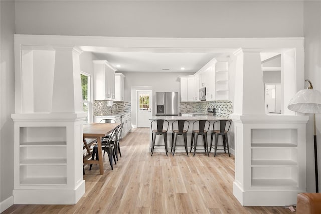 kitchen with light hardwood / wood-style flooring, white cabinets, sink, and stainless steel appliances