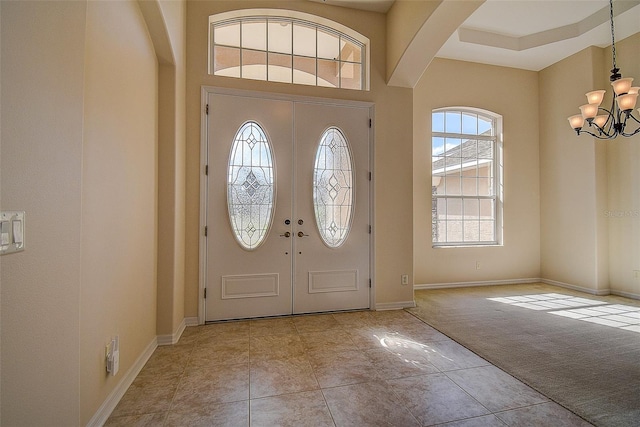 entryway with light colored carpet and a chandelier