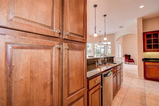 kitchen with light tile patterned flooring, a textured ceiling, pendant lighting, sink, and stainless steel dishwasher