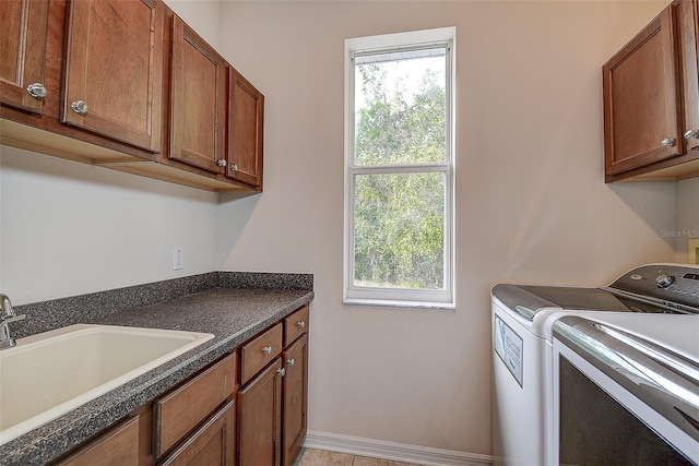 washroom featuring cabinets, light tile patterned floors, sink, and washing machine and clothes dryer