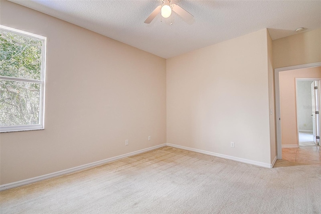 carpeted empty room with a textured ceiling and ceiling fan