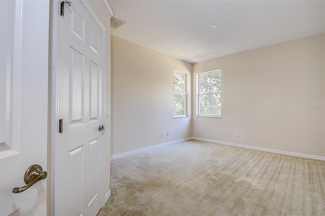 carpeted spare room with a textured ceiling