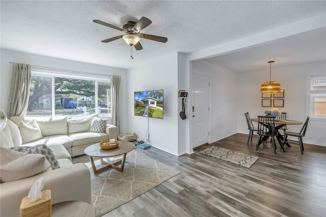 living room with a textured ceiling, hardwood / wood-style flooring, and ceiling fan