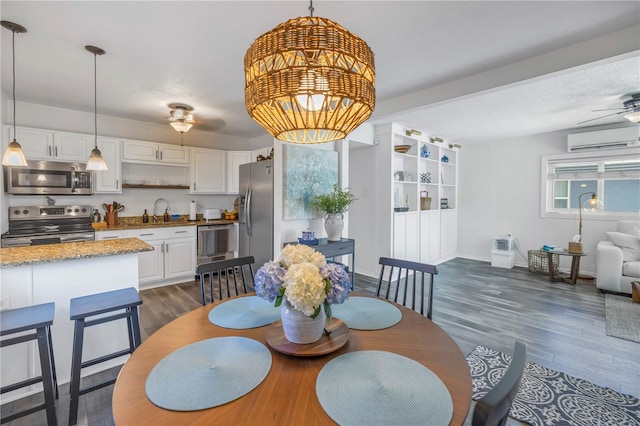 dining room featuring ceiling fan, a wall unit AC, dark hardwood / wood-style floors, and sink