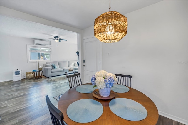 dining room featuring ceiling fan, a wall unit AC, and wood-type flooring