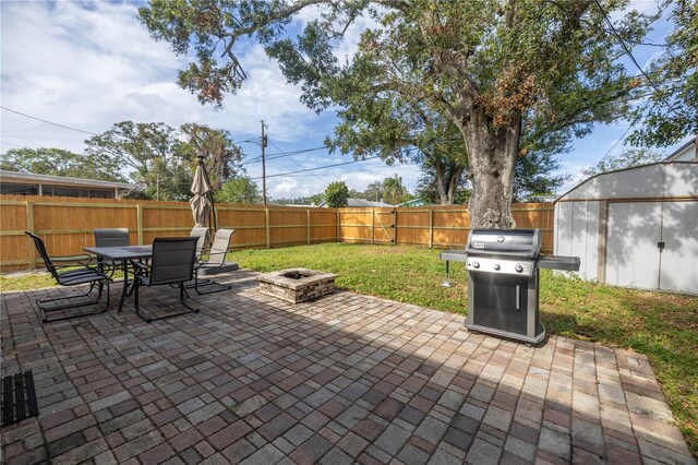 view of patio featuring a storage unit, area for grilling, and an outdoor fire pit