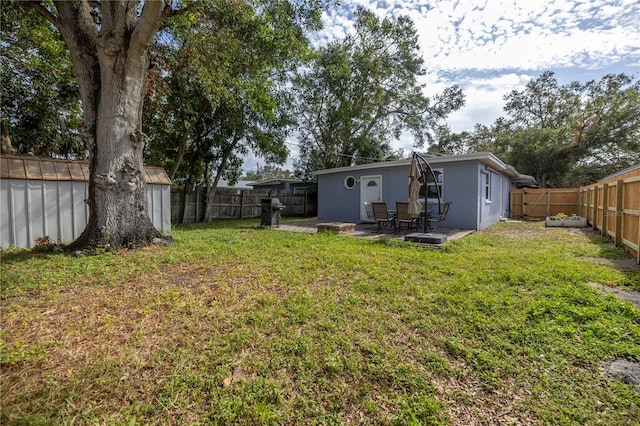 view of yard featuring a shed and a patio area