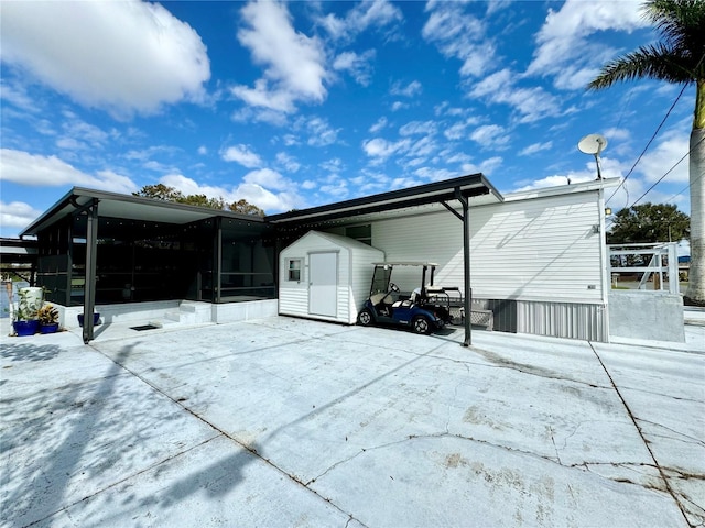 back of property with a shed and a sunroom