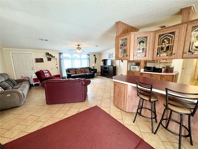 living room featuring light tile patterned flooring, a textured ceiling, and ceiling fan