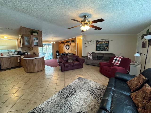 tiled living room featuring ceiling fan, a textured ceiling, sink, and crown molding