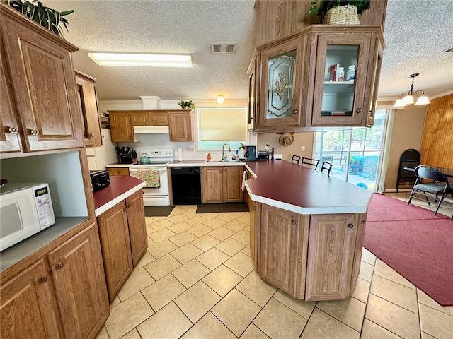 kitchen with white appliances, a textured ceiling, and hanging light fixtures