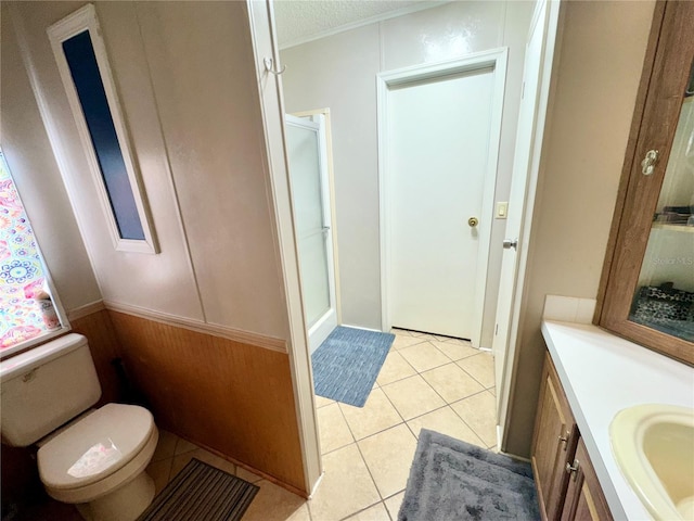 bathroom with walk in shower, vanity, a textured ceiling, tile patterned flooring, and toilet