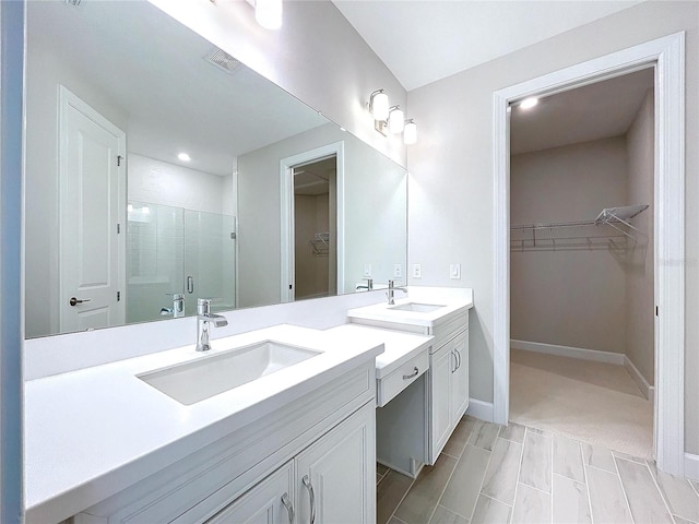 bathroom with vanity and a shower with door