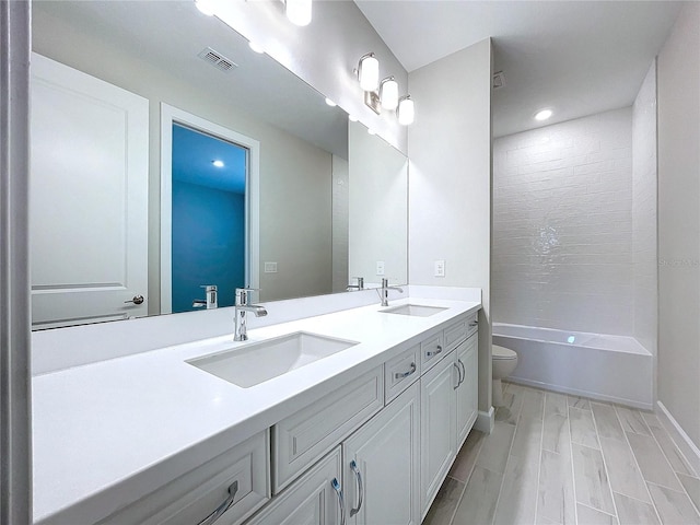 full bathroom with vanity, toilet, and tiled shower / bath