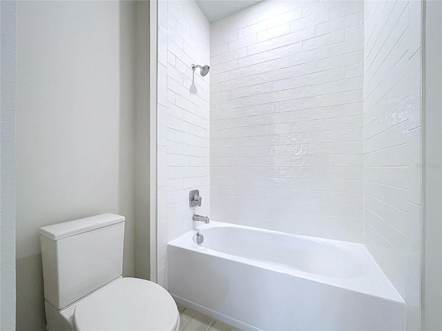 bathroom with tiled shower / bath combo and toilet