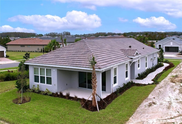 back of property featuring a patio area and a yard