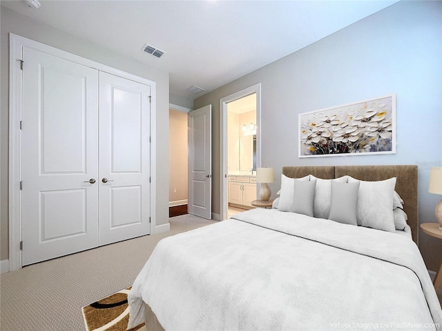 bedroom featuring light colored carpet, a closet, and ensuite bathroom