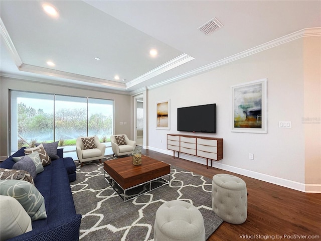 living room with a tray ceiling, crown molding, and dark wood-type flooring