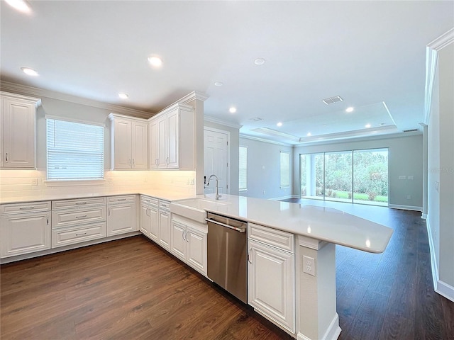 kitchen with kitchen peninsula, sink, stainless steel dishwasher, dark hardwood / wood-style floors, and white cabinetry